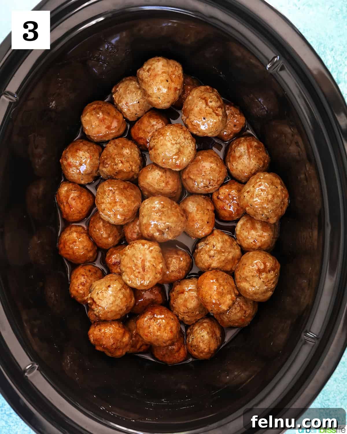 Honey Bourbon Glazed Meatballs (Slow Cooker Recipe) 8 Sauce poured over meatballs in a slow cooker.
