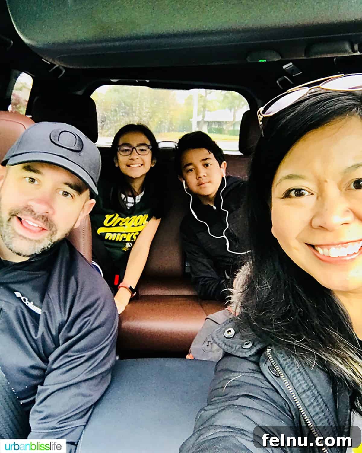 Essential Road Trip Tips Plus Your Free Planner 3 A family of four happily seated in their car, ready for a fun road trip adventure.