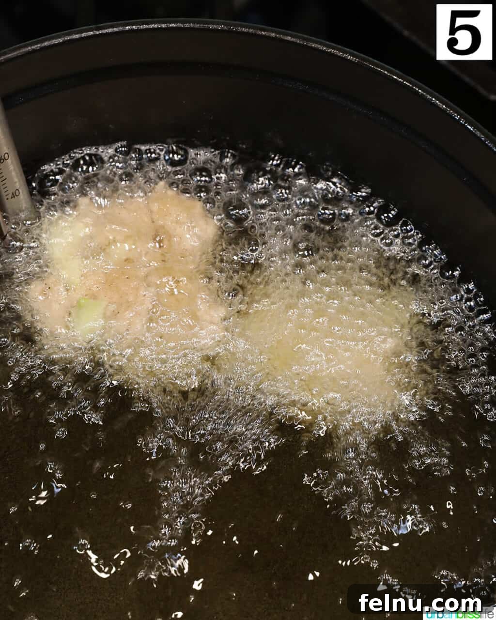 Crispy Cinnamon Apple Fritters 12 Apple fritter donuts frying in hot oil in a Dutch oven.