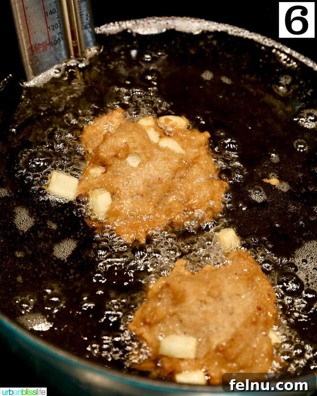 Crispy Cinnamon Apple Fritters 13 Apple fritter donuts continuing to fry in the Dutch oven, turning golden.