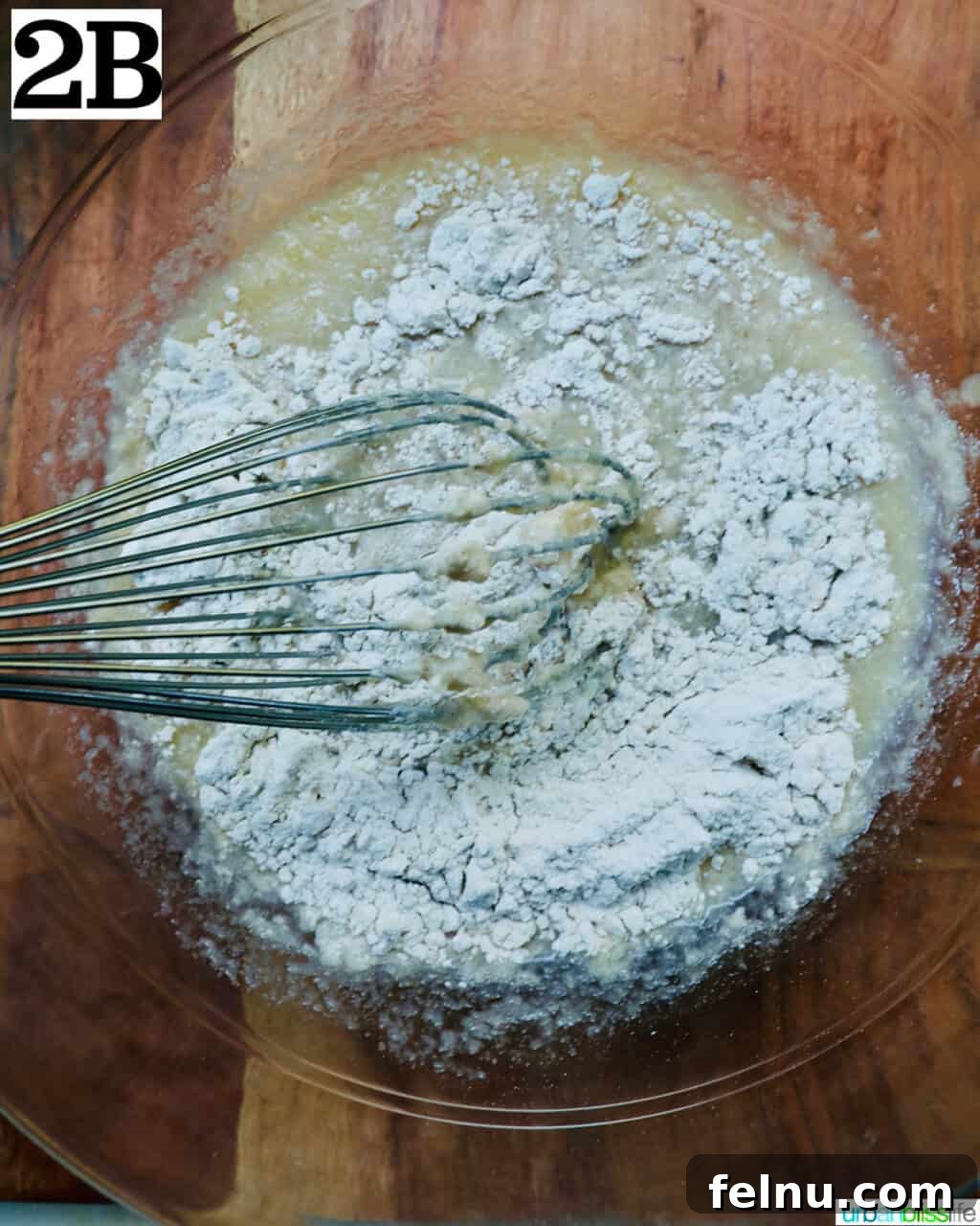 Crispy Cinnamon Apple Fritters 9 Mixing dry ingredients into wet ingredients to form apple fritter batter.