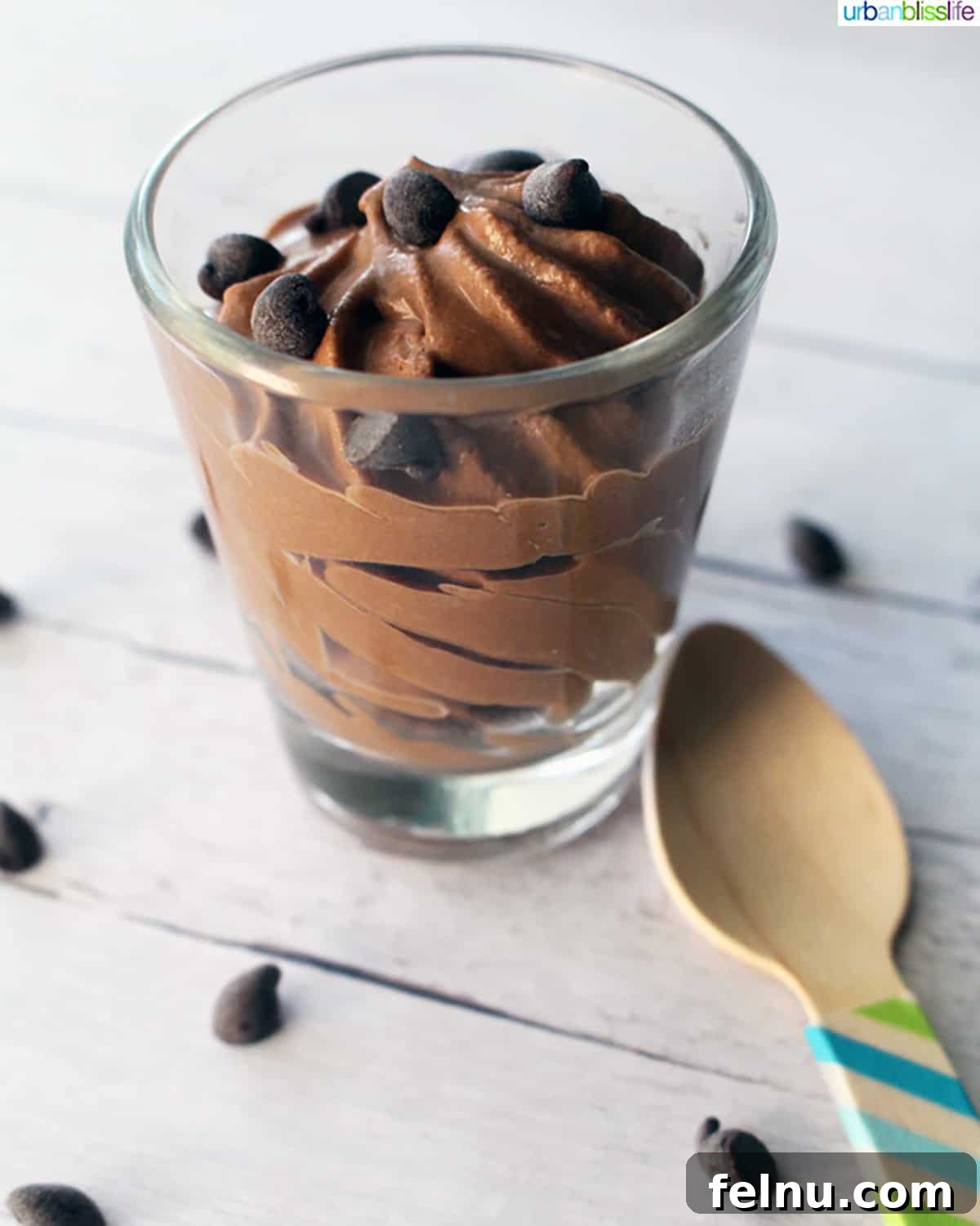 Dairy-free chocolate mousse in a shot glass with a wooden spoon