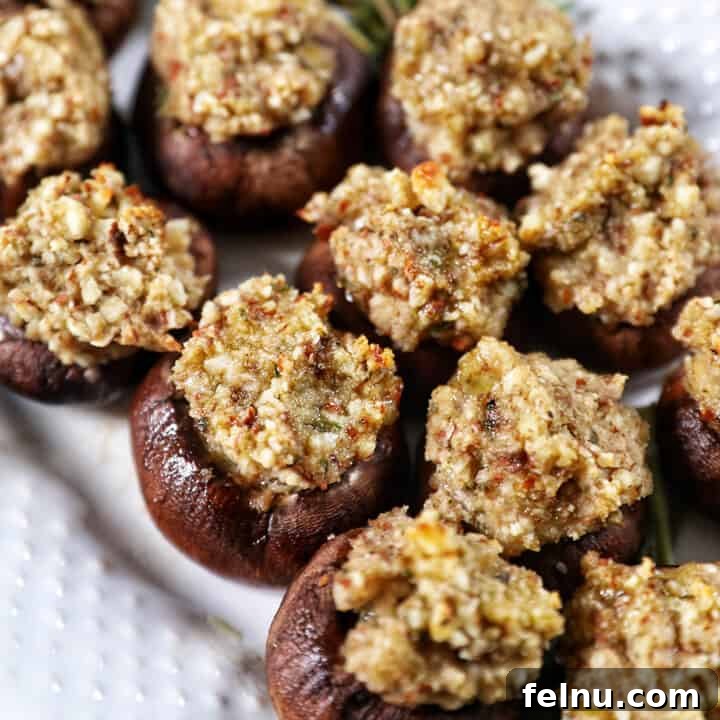 Vegan Delight: Savory Mushroom Caps 11 Vegan Stuffed Mushrooms close together on a white platter.