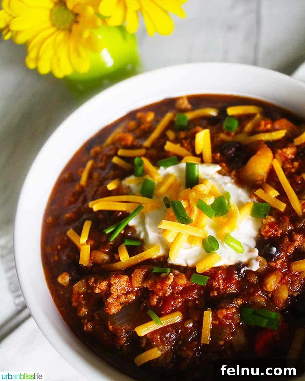 Hearty Dutch Oven Turkey Chili with Farro and Stout 3 A vibrant bowl of Dutch oven turkey chili, generously garnished with fresh cilantro, a dollop of sour cream, and shredded cheese, inviting you to dive in.