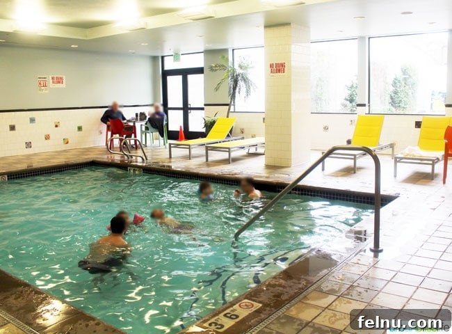 The kid-friendly swimming pool at The Maxwell Hotel Seattle, featuring colorful decor and comfortable lounge chairs.