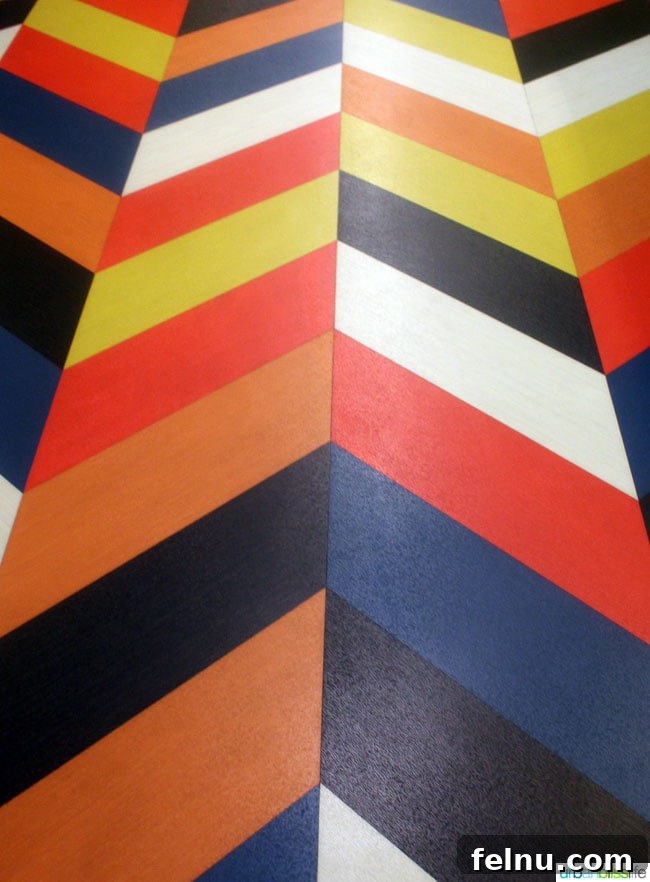 Colorful striped artwork on the floor of an elevator landing at The Maxwell Hotel Seattle.