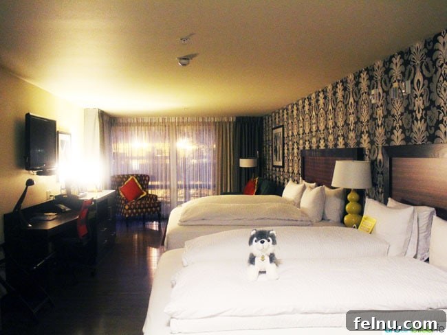 A beautifully decorated guest room at The Maxwell Hotel Seattle, featuring comfortable king-sized beds and modern amenities.