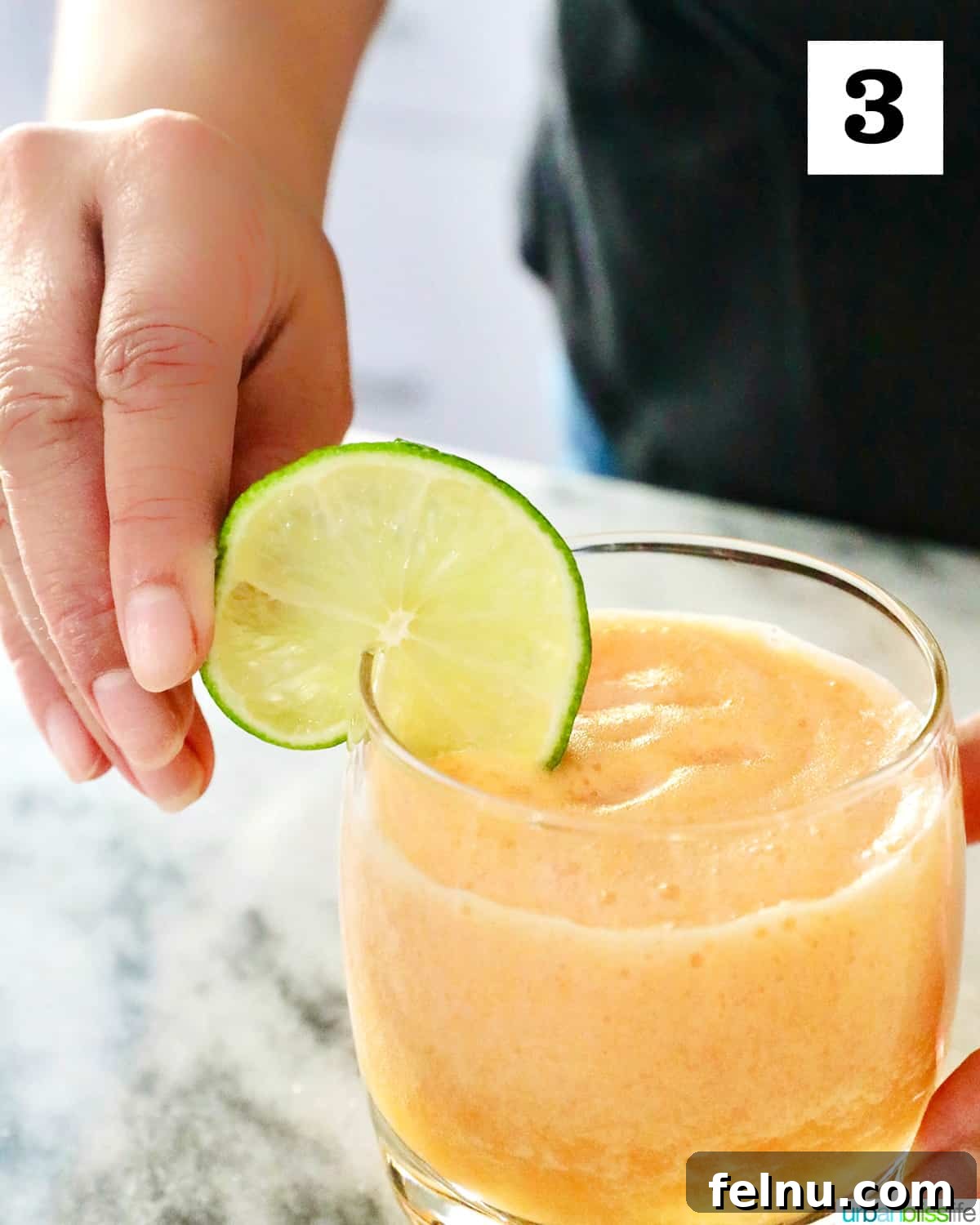 Adding lime slice to cantaloupe margarita.