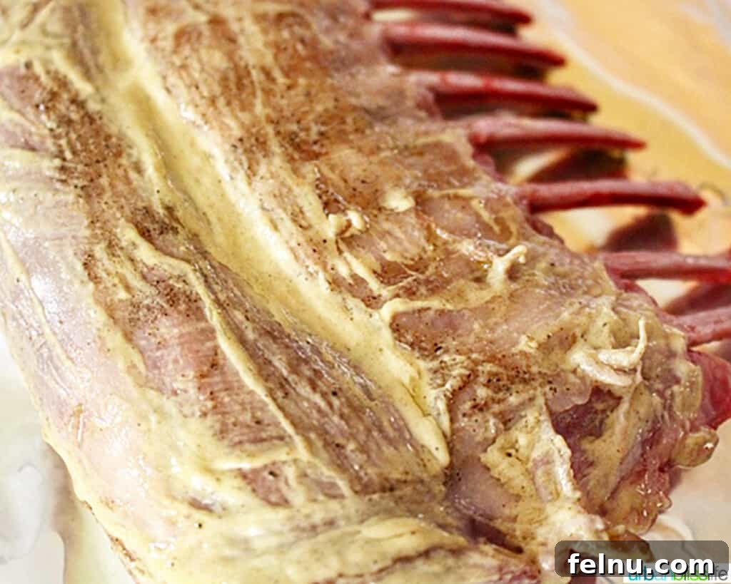 Aromatic Herb-Crusted Lamb Rack with Sweet-Tart Blackberry Balsamic 5 Dijon mustard being brushed onto a rack of lamb before the herb crust