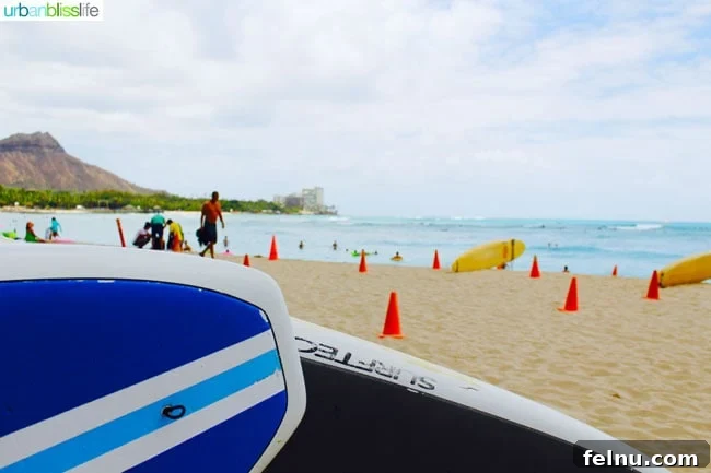 Outrigger Waikiki Beach Resort: Your Honolulu Home Away From Home 2 Surfboards lined up on Waikiki Beach, ready for a day of fun.