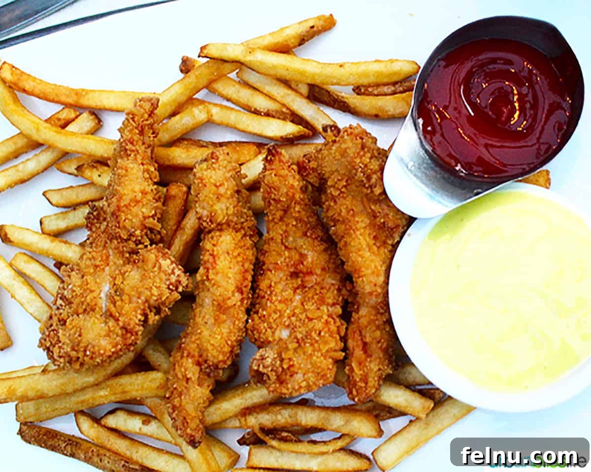 Vancouver BC's Cactus Club Cafe 10 breaded chicken tenders on french fries with ketchup and honey mustard.