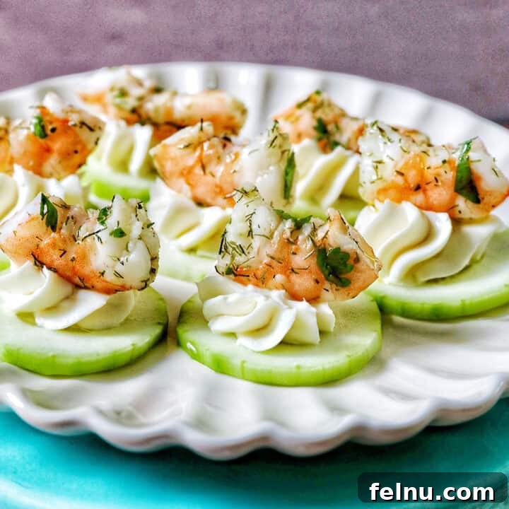 Beautifully arranged shrimp cucumber cream cheese appetizers on a scalloped plate, ready for serving.