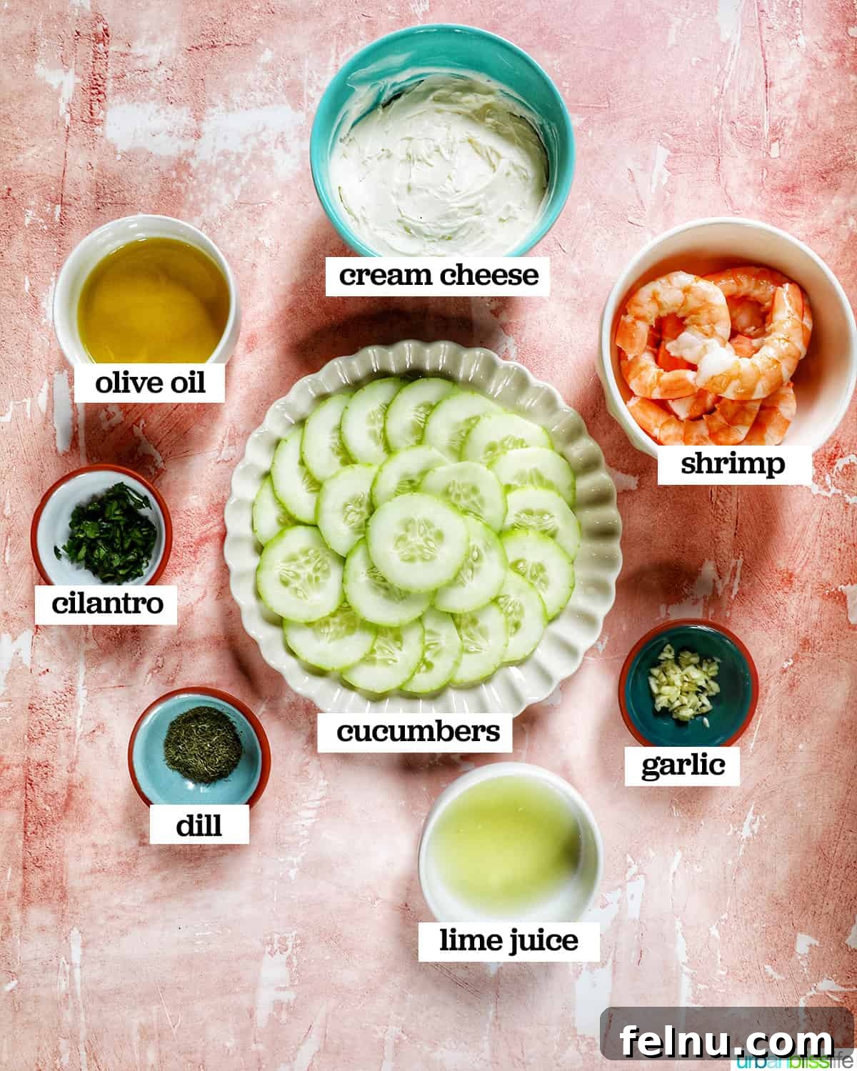 Crisp Cucumber Shrimp Delights 4 A vibrant flat lay of ingredients laid out on a peach background, including bowls of shrimp, cucumbers, cream cheese, and fresh herbs, ready to make cucumber shrimp canapés.