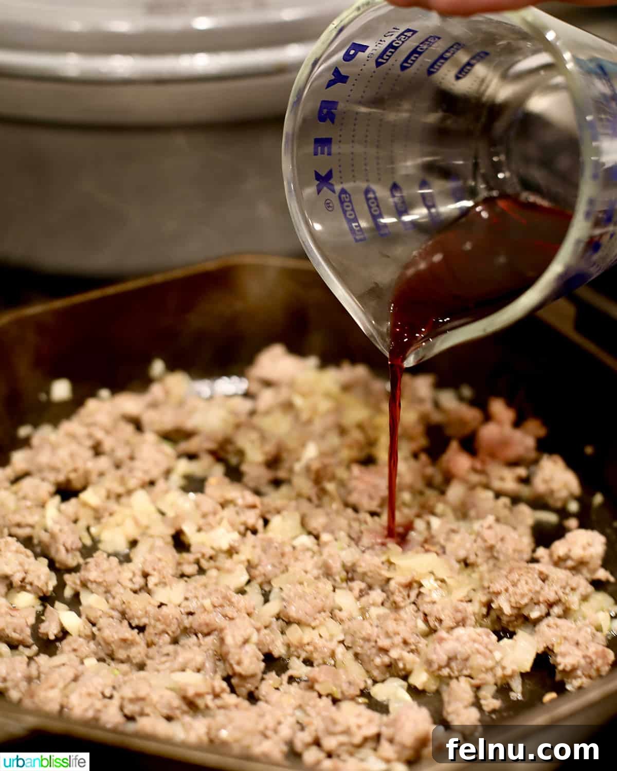 Effortless Italian Sausage Rigatoni Delight 7 Adding beef broth to the cooked sausage mixture.