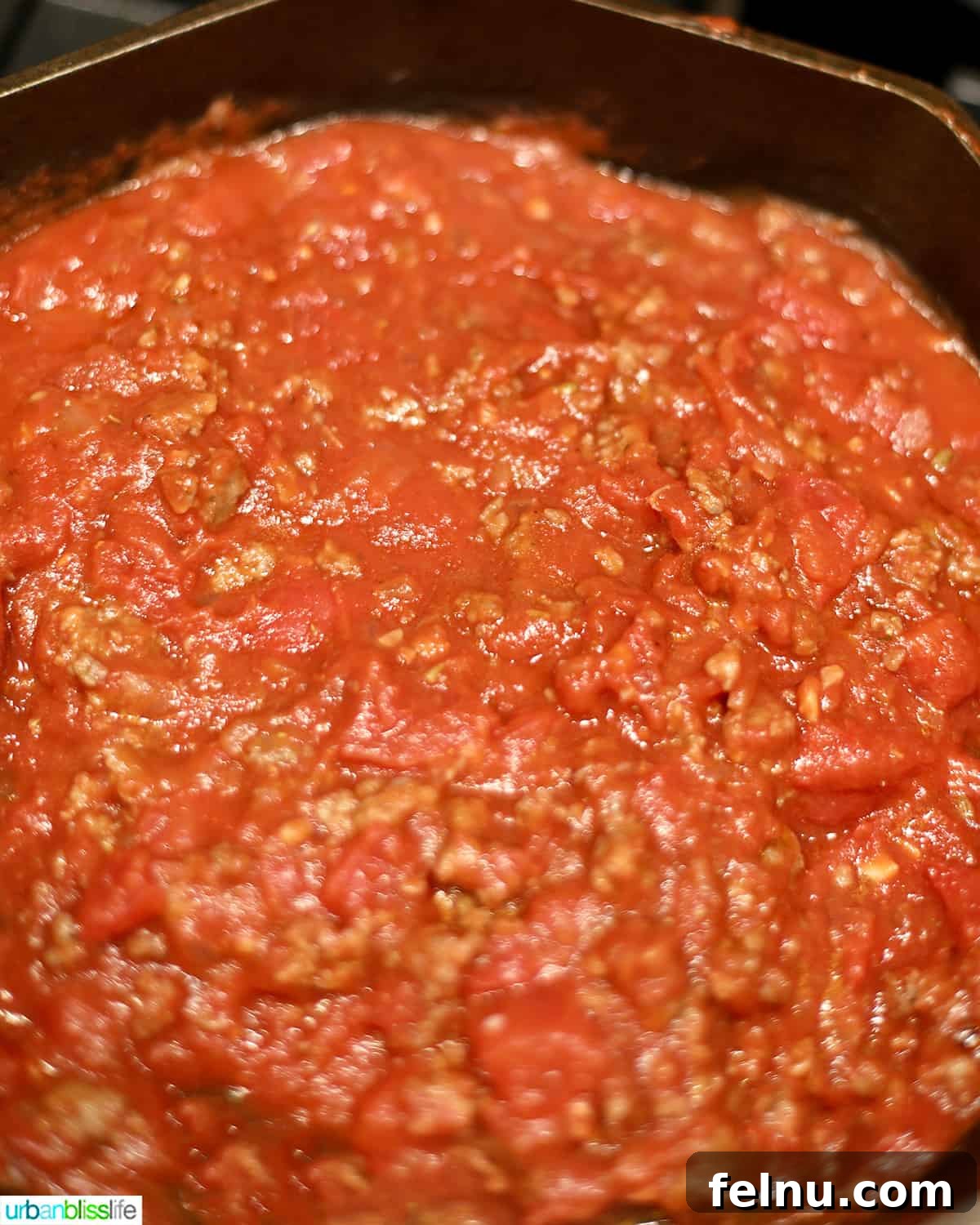 Effortless Italian Sausage Rigatoni Delight 8 Adding diced tomatoes to the skillet.