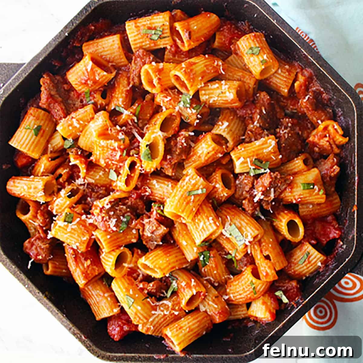 Effortless Italian Sausage Rigatoni Delight 10 Rigatoni with Italian sausage in a cast iron skillet.