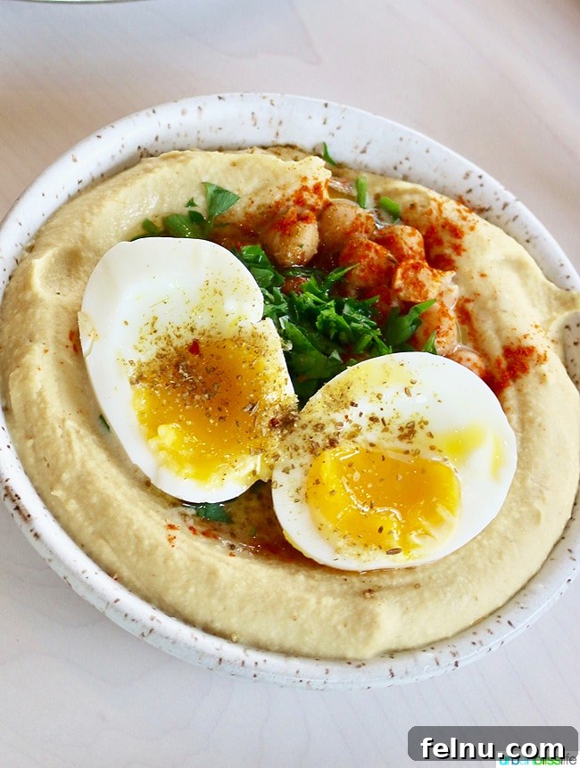 Middle Eastern Brunch Magic at Tusk 17 A generous serving of Tusk's acclaimed hummus, served with warm flatbread, paprika, and fresh parsley, perfect for dipping.