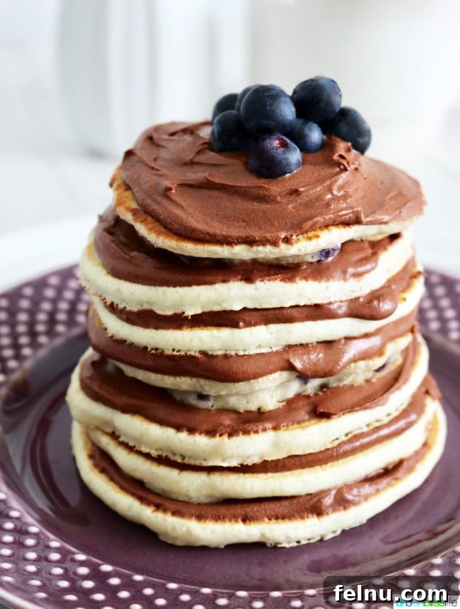 Rich Chocolate Pancake Towers with Pillowy Frosting 6 Chocolate Pancake Cake Stacks with Dairy-Free Chocolate Frosting and blueberries