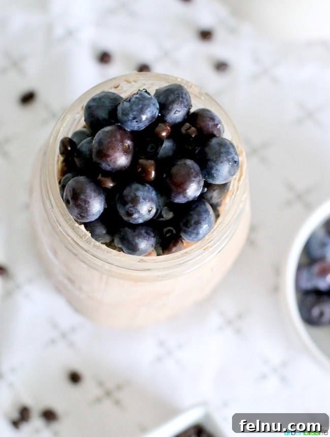 Fresh blueberries added to a jar of overnight oats