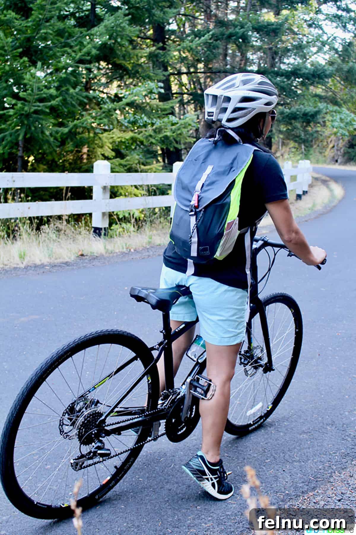 50 Unforgettable Kid-Friendly Adventures in Portland 7 A woman on a bicycle smiles brightly while riding through a scenic area in Portland, Oregon, highlighting the city's bike-friendly culture.