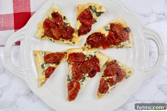 Creamy Tomato Flatbread Pizza Delight 4 A finished Tomato Cream Cheese Flatbread Pizza, sliced and ready to serve, showcasing its fresh ingredients.