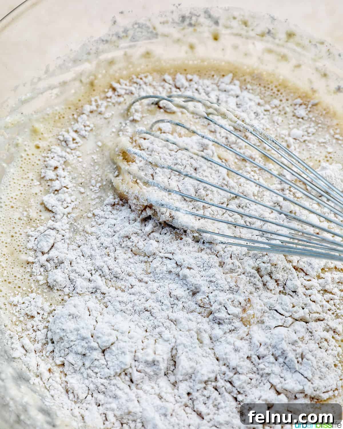 Effortless Chocolate Chunk Banana Bread 8 Whisking the dry ingredients together to ensure even distribution of baking powder and soda.