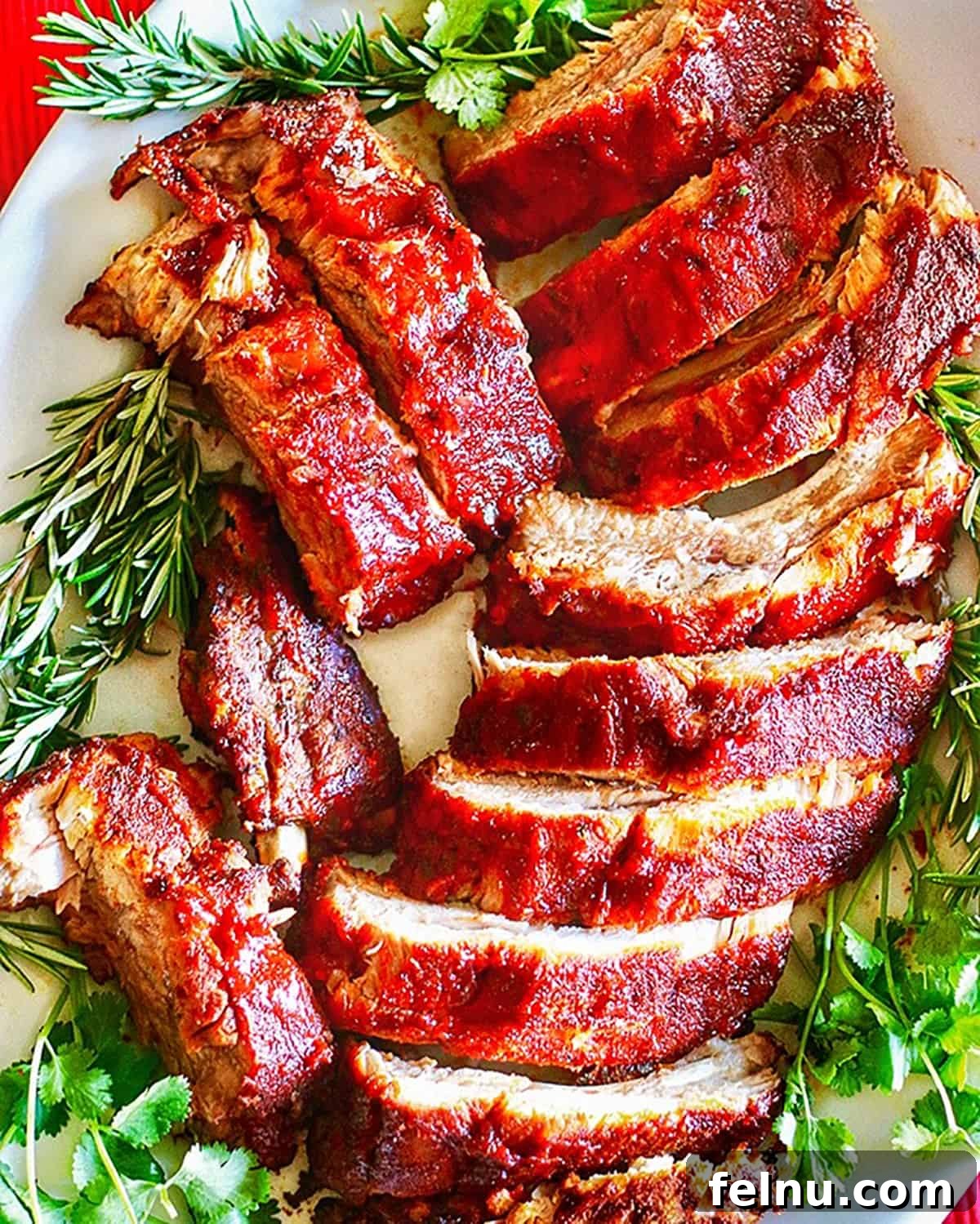 Sip, Sizzle, Savor: Wines That Perfect Your BBQ 9 A plate full of tender, sliced Instant Pot pork ribs, beautifully garnished with fresh rosemary and other aromatic herbs.