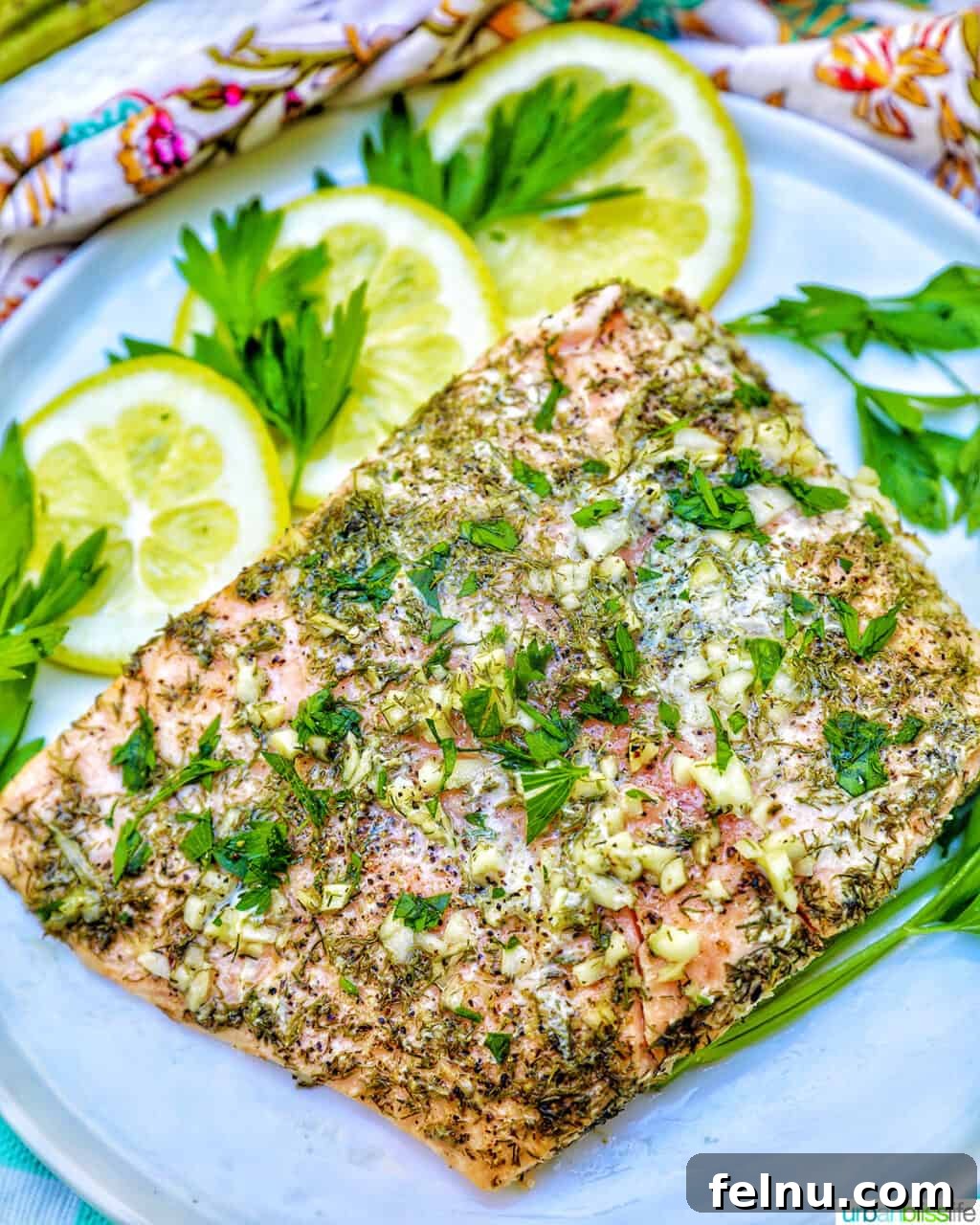 Zesty Lemon Herb Salmon Delight 2 Grilled salmon with lemon, garlic, and herbs, with lemon slices on a white plate.