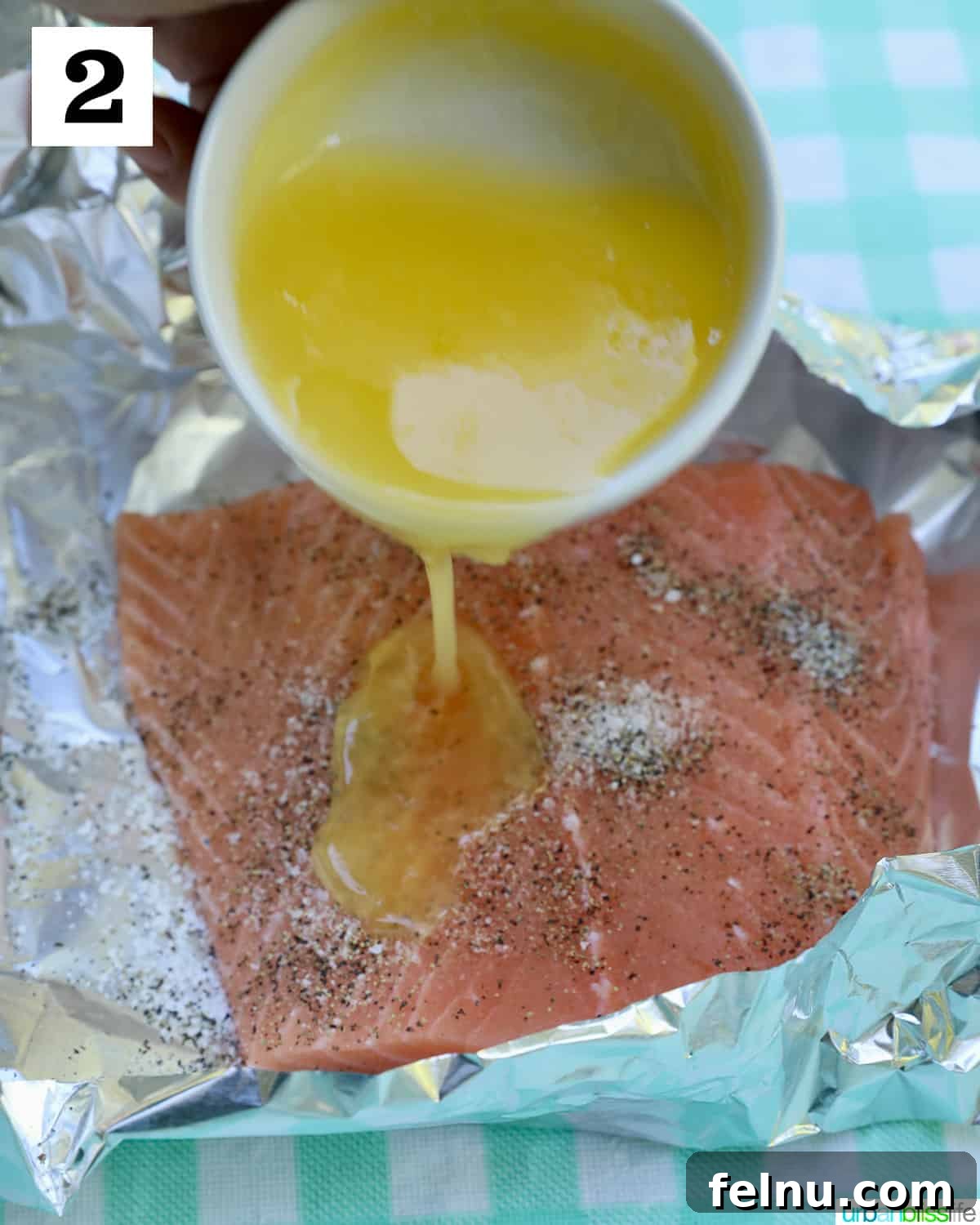 Zesty Lemon Herb Salmon Delight 6 Butter poured over seasoned salmon in foil.