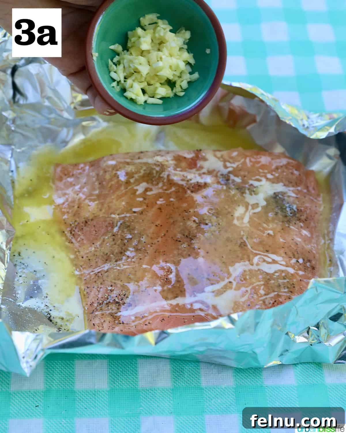Zesty Lemon Herb Salmon Delight 7 Garlic added to seasoned salmon in foil.
