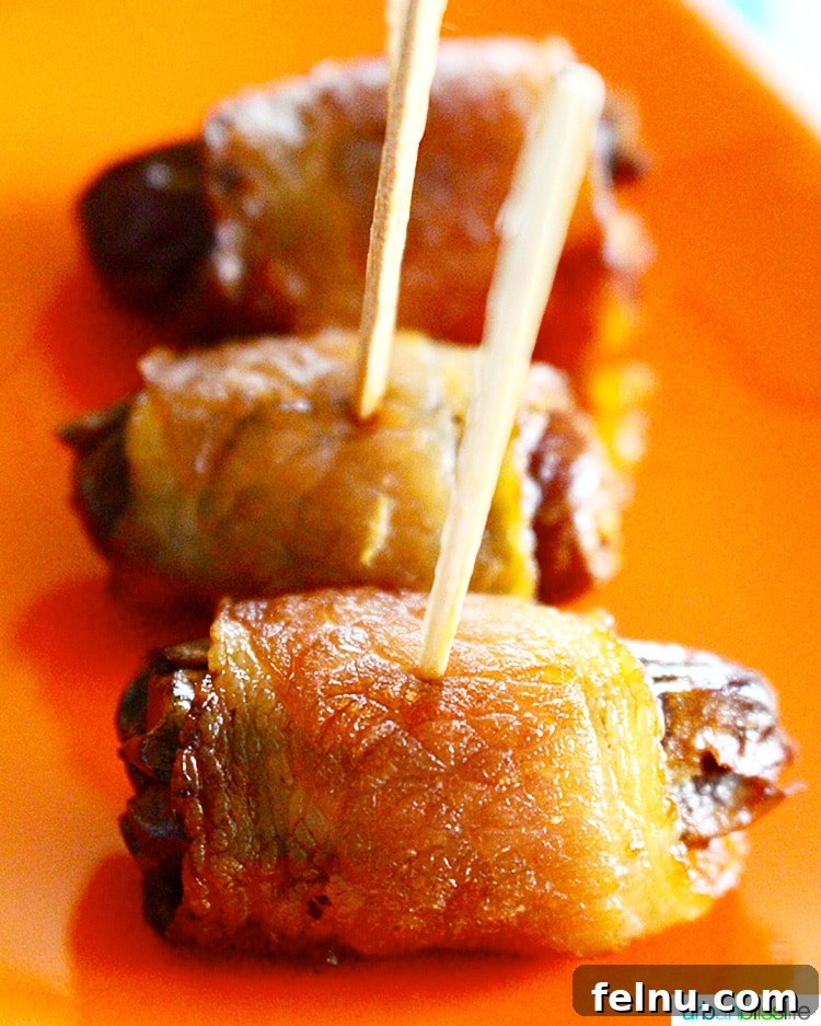 Smoky Bacon-Wrapped Dates with Creamy Goat Cheese 3 Bacon-Wrapped Dates with Goat Cheese, arranged elegantly for a party.