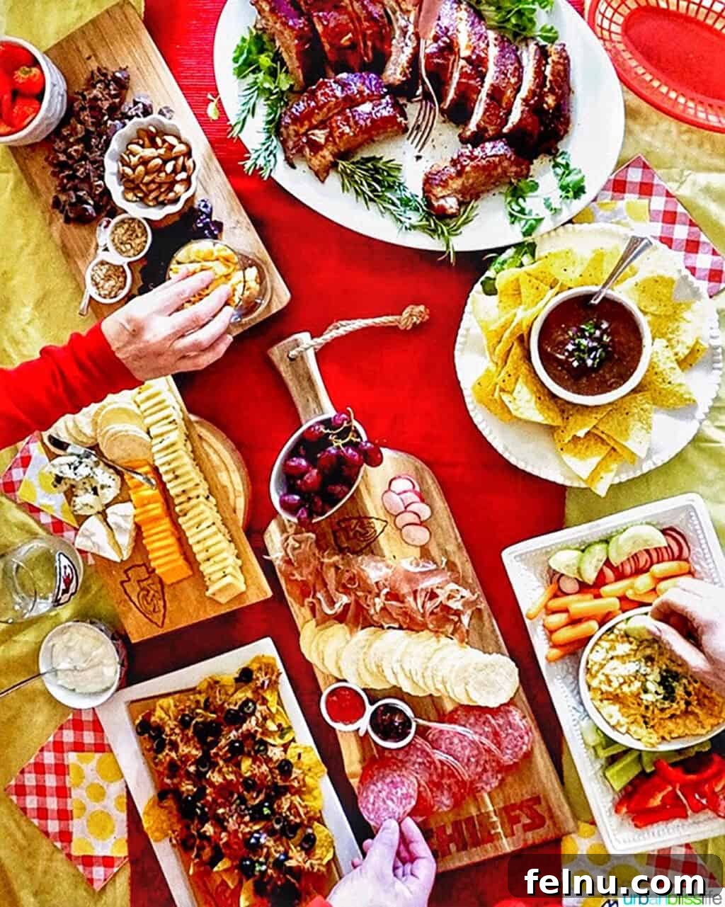 Fall-Off-The-Bone Instant Pot Ribs with Homemade BBQ 10 A vibrant football game day food spread featuring Instant Pot pork ribs, pulled pork nachos, restaurant style salsa and chips, and other finger foods on a red & yellow themed table.