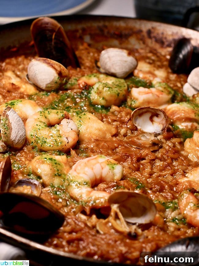 Classic Paella de Peix with fresh seafood including monkfish, clams, mussels, and shrimp.