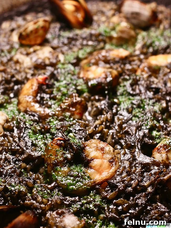 Striking Arròs Negre paella, a squid ink paella with seafood and garlic aioli.