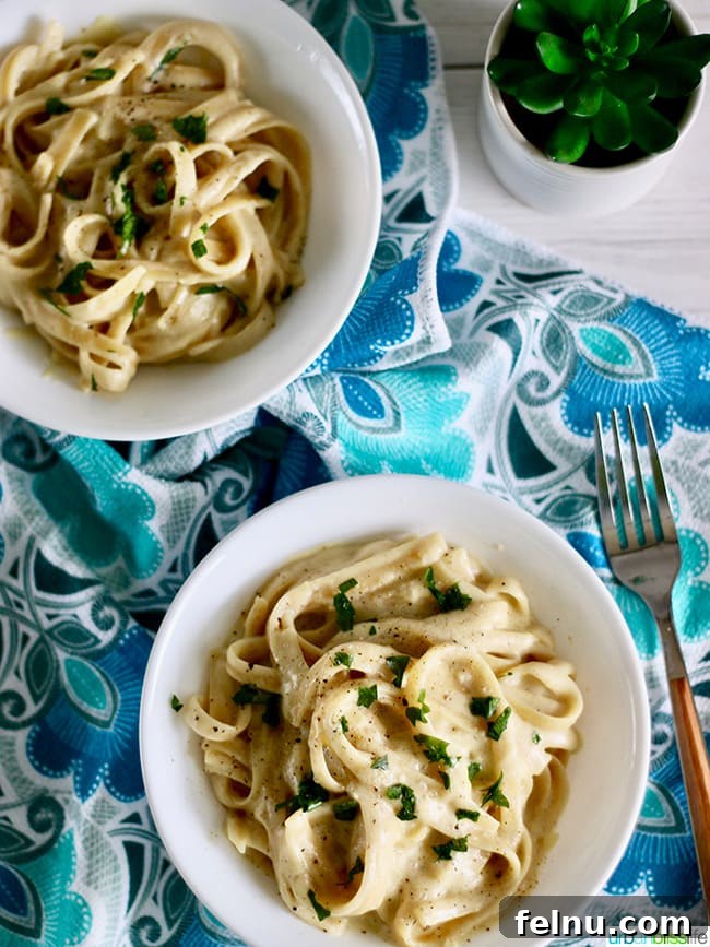 Velvet-Smooth Vegan Fettuccine Alfredo 10 Two bowls of dairy free vegan alfredo sauce with fettucini and wine glasses