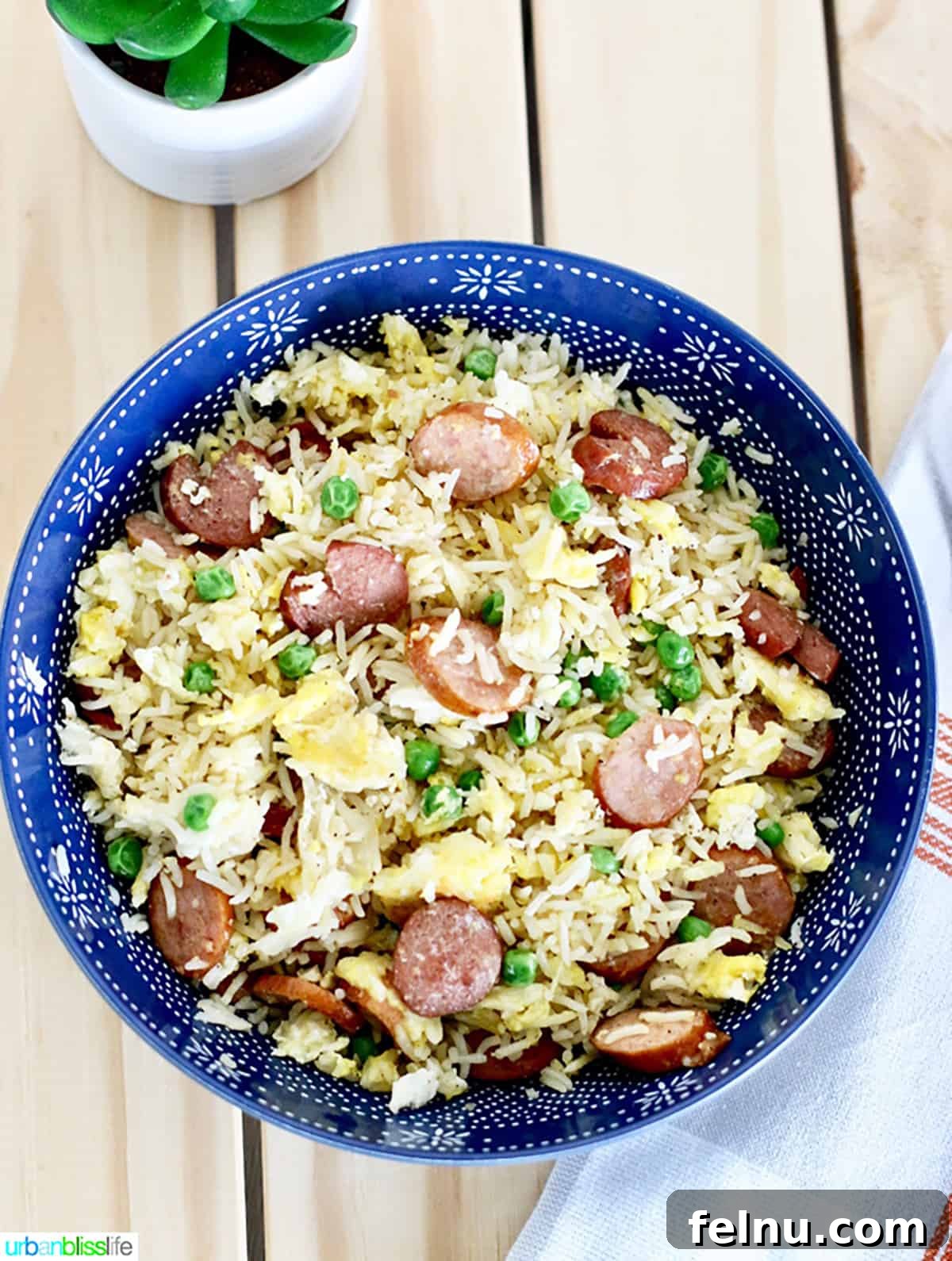 Filipino Fried Rice Your Choice of Bacon or Sausage 3 Bowl of Filipino Fried Rice with sliced sausages and fresh parsley garnish.