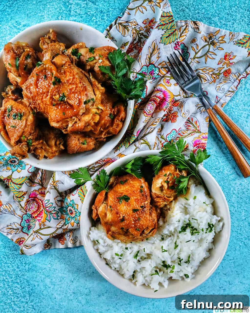 Ultimate Instant Pot Chicken Adobo 15 two bowls of Instant Pot Filipino Chicken Adobo and rice, with a colorful floral napkin and forks.