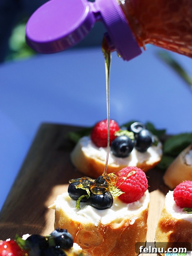 Ricotta Crostini Topped with Summer Berries and Honey Drizzle 5 Honey drizzling over berries and ricotta crostini