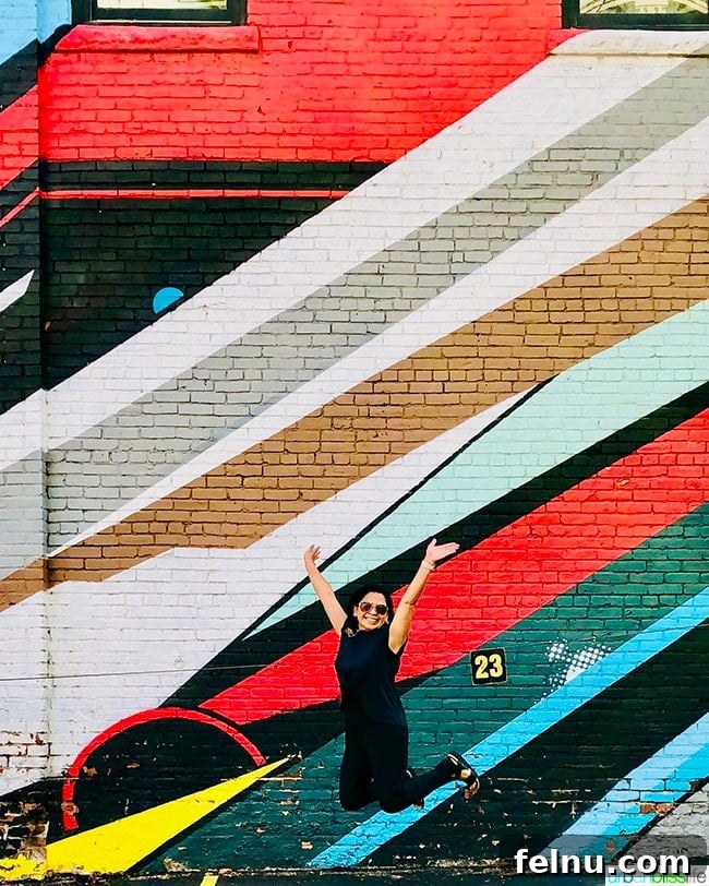 Colorado Peaks and Pavement 34 Marlynn Schotland doing a jump shot in front of a colorful Denver, Colorado mural
