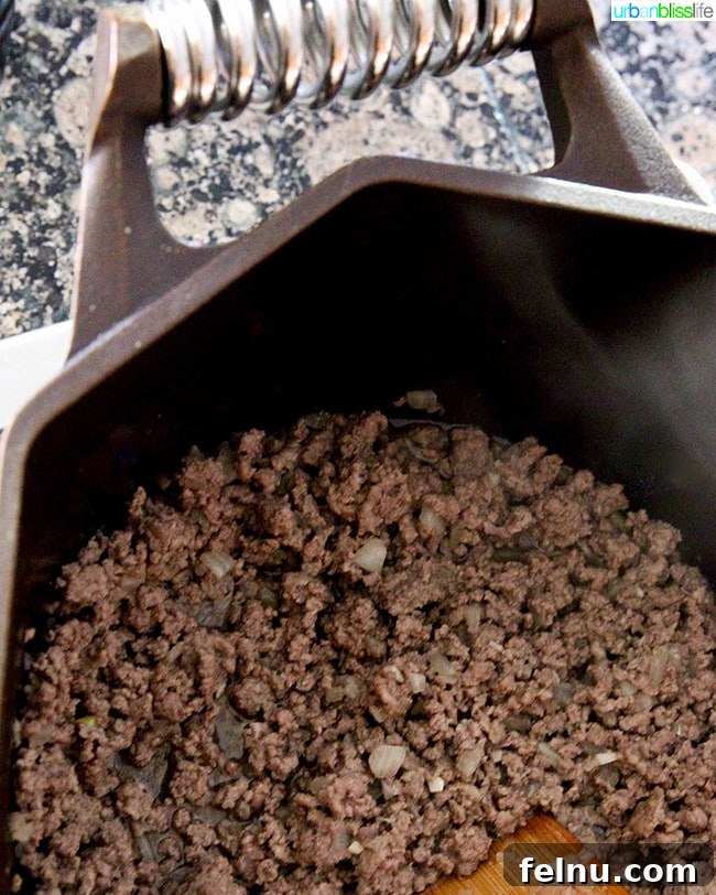 Hearty Dutch Oven Shepherd's Pie 5 Ground beef cooking in a Dutch oven.