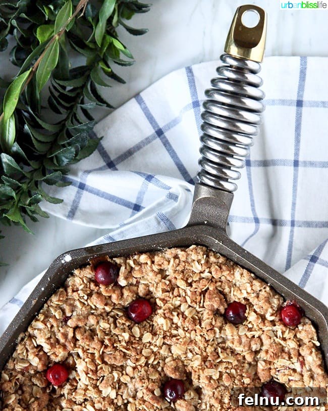 The golden, bubbly bottom of a skillet apple cranberry crisp, hinting at the delicious fruit filling.