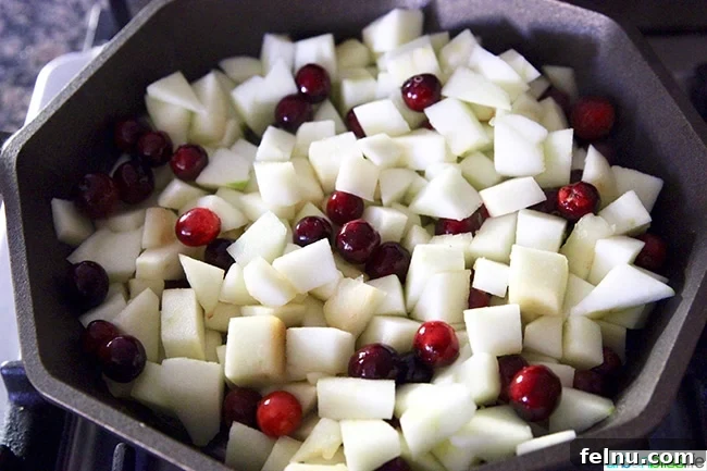 Peeled and chopped Granny Smith apples in a cast iron skillet, ready for the filling preparation.