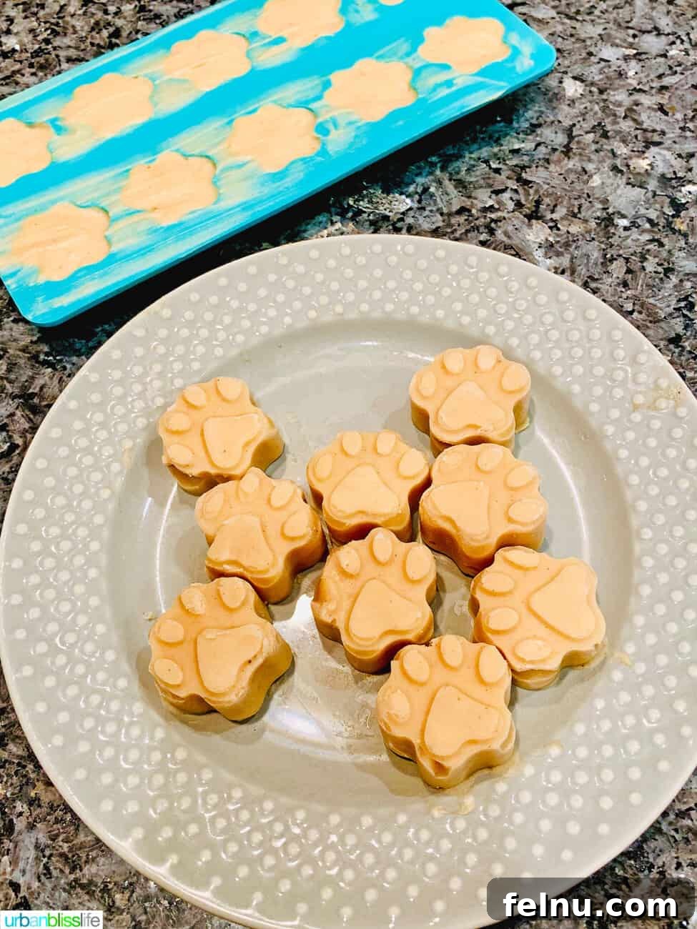 Frozen Banana Peanut Butter Pupsicles 12 frozen peanut butter banana dog treats on a plate with some in the mold
