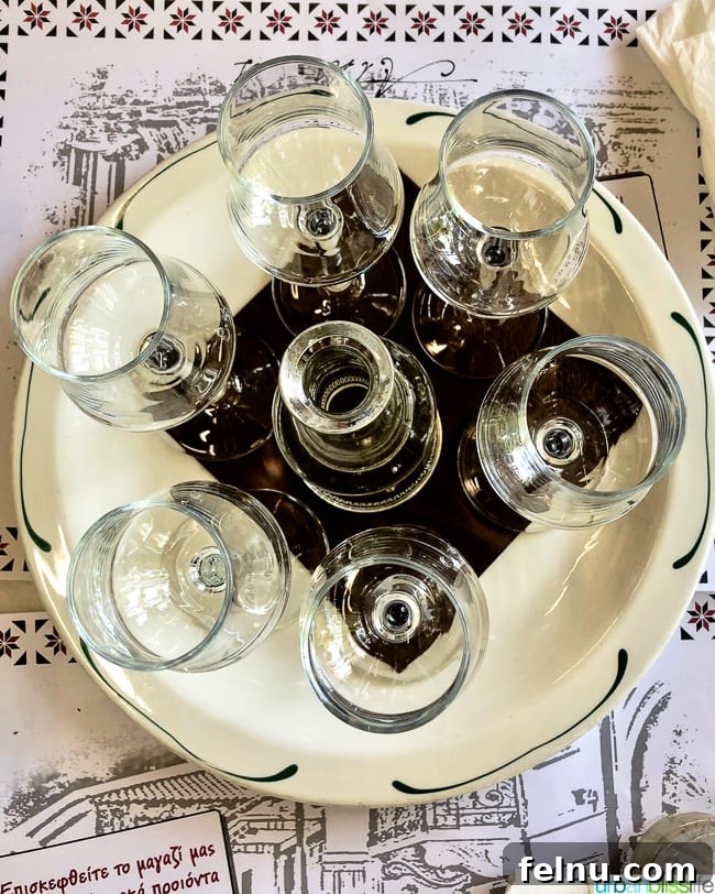Glasses of Tsipouro served on a tray, a traditional Greek spirit enjoyed at Dia Tafta restaurant
