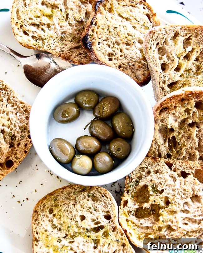 A delicious offering of fresh olives and rustic bread, a staple of Greek cuisine served at Dia Tafta