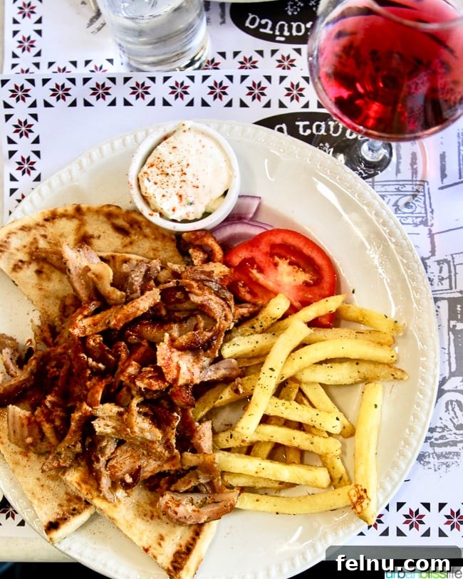 A traditional Gyro served with pita bread, tzatziki, and fries, a satisfying meal enjoyed at Dia Tafta