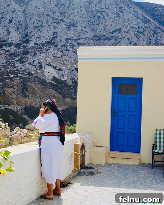 Greece Travel: Discover Olympos Village, Karpathos 19 A Karpathian woman in traditional dress using a cell phone in Olympos, Greece