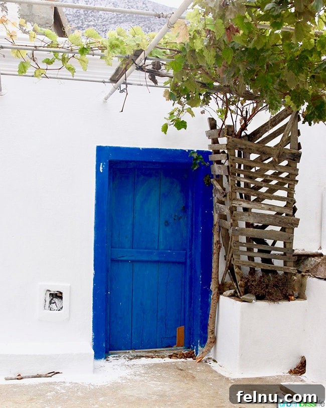 Greece Travel: Discover Olympos Village, Karpathos 6 A whitewashed house with a bright blue door in Avlona, Karpathos
