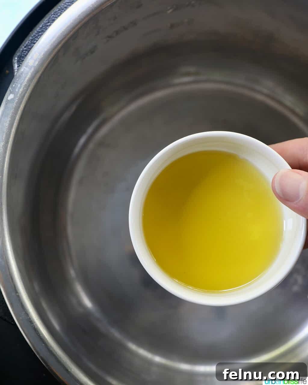 Zesty Instant Pot Lemon Garlic Chicken 4 bowl of olive oil being poured into the Instant Pot.