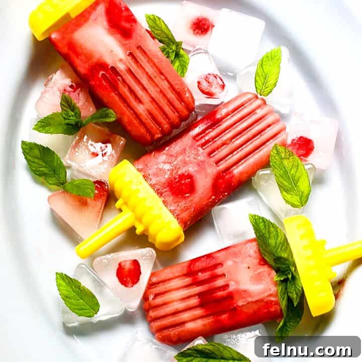 Sweet Tart Strawberry Rhubarb Pops 6 strawberry rhubarb mint popsicles on a white platter.